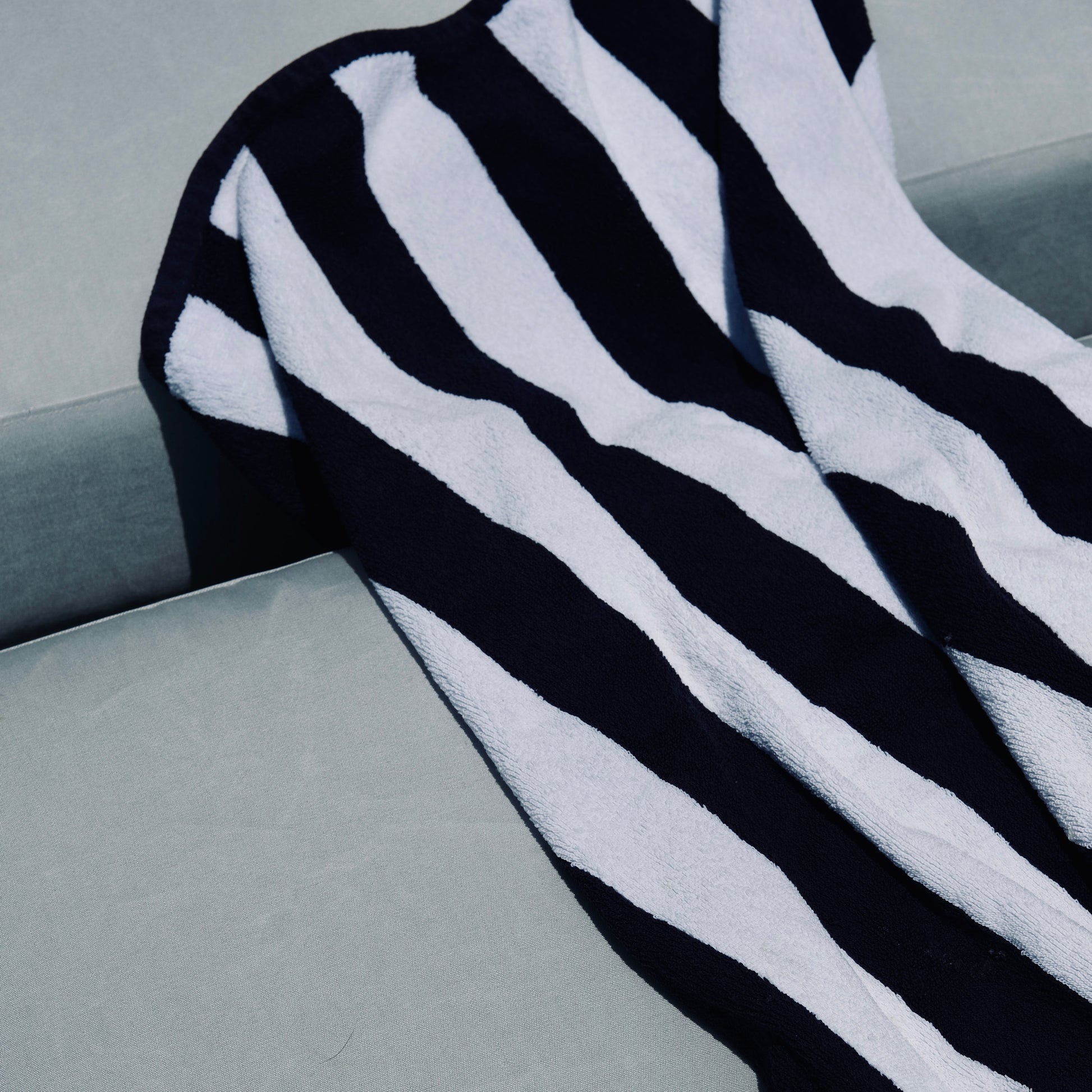 Black and white striped blanket draped over a outdoor chair