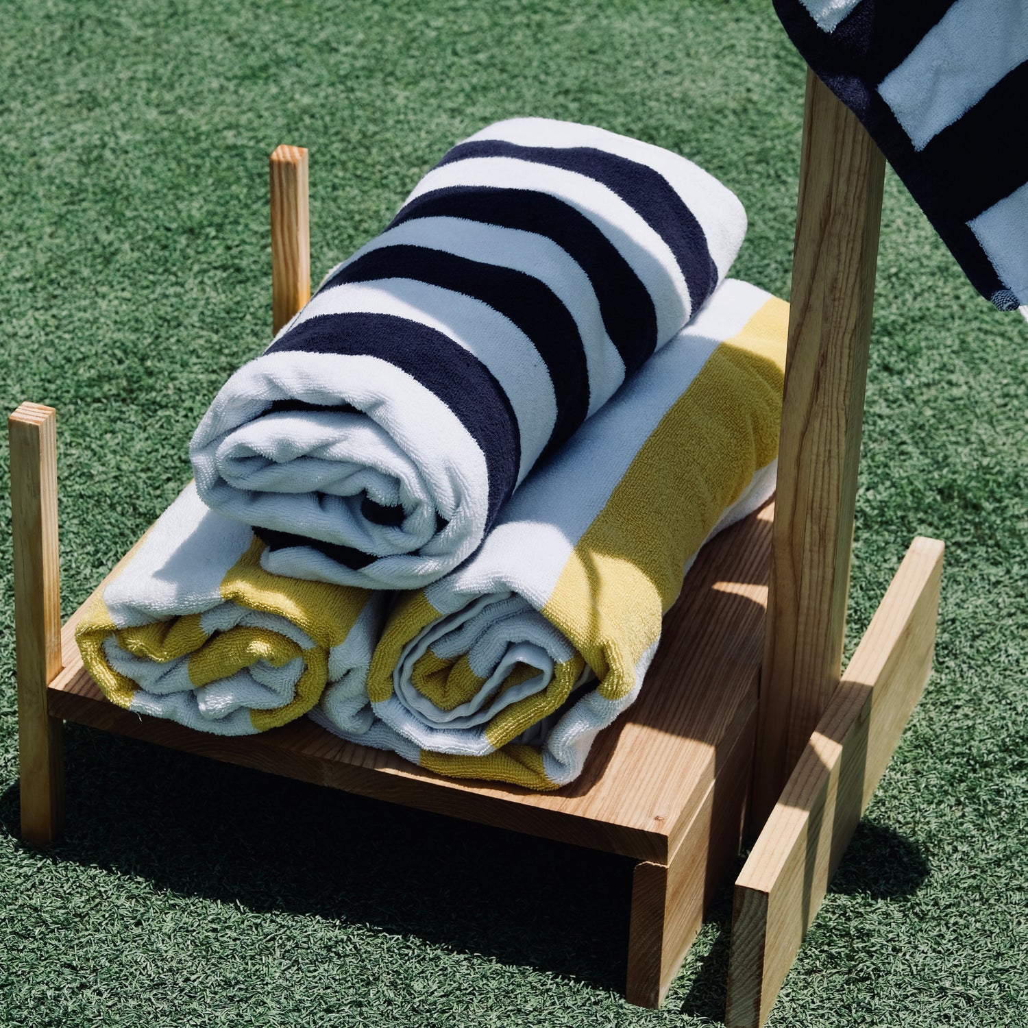 Stack of folded towels on a wooden stand outdoors