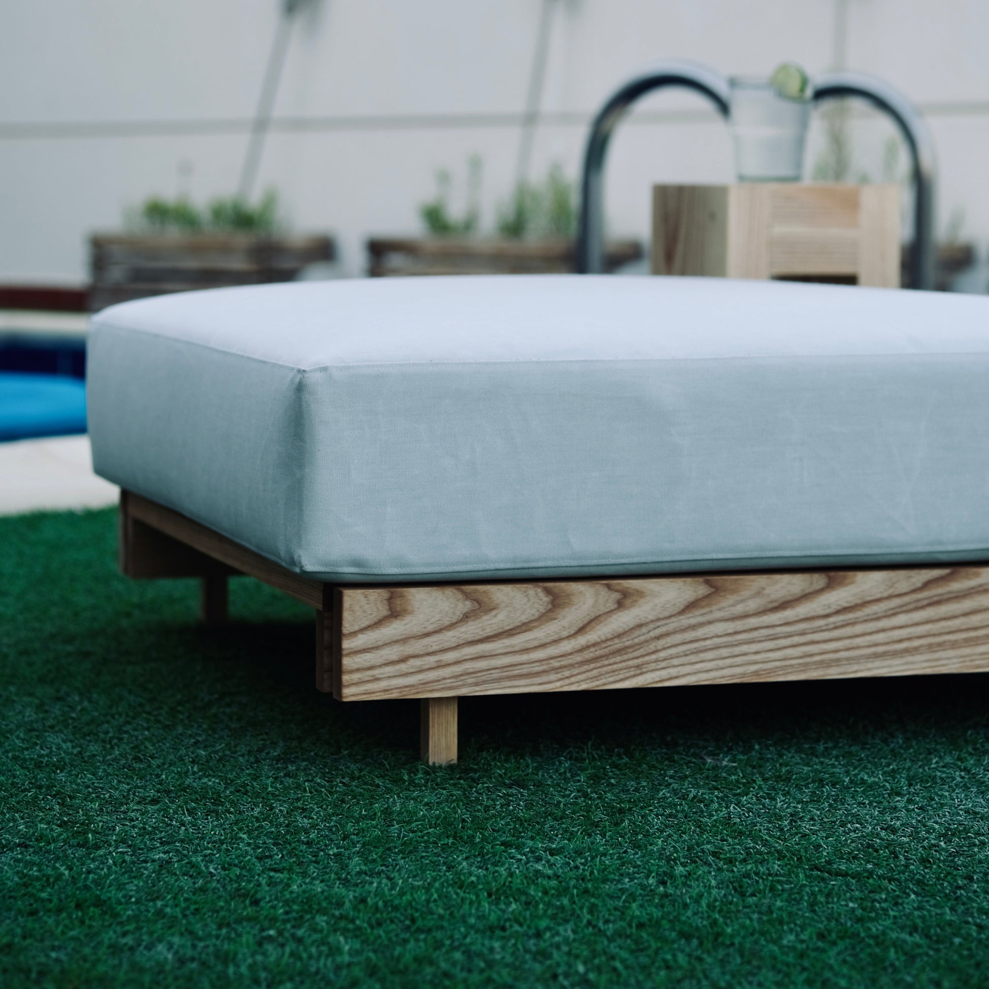 Outdoor sofa with light blue cushion on a grassy area