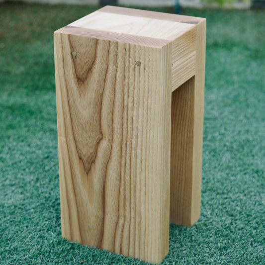 Wooden drink table on a grassy surface with greenery in the background