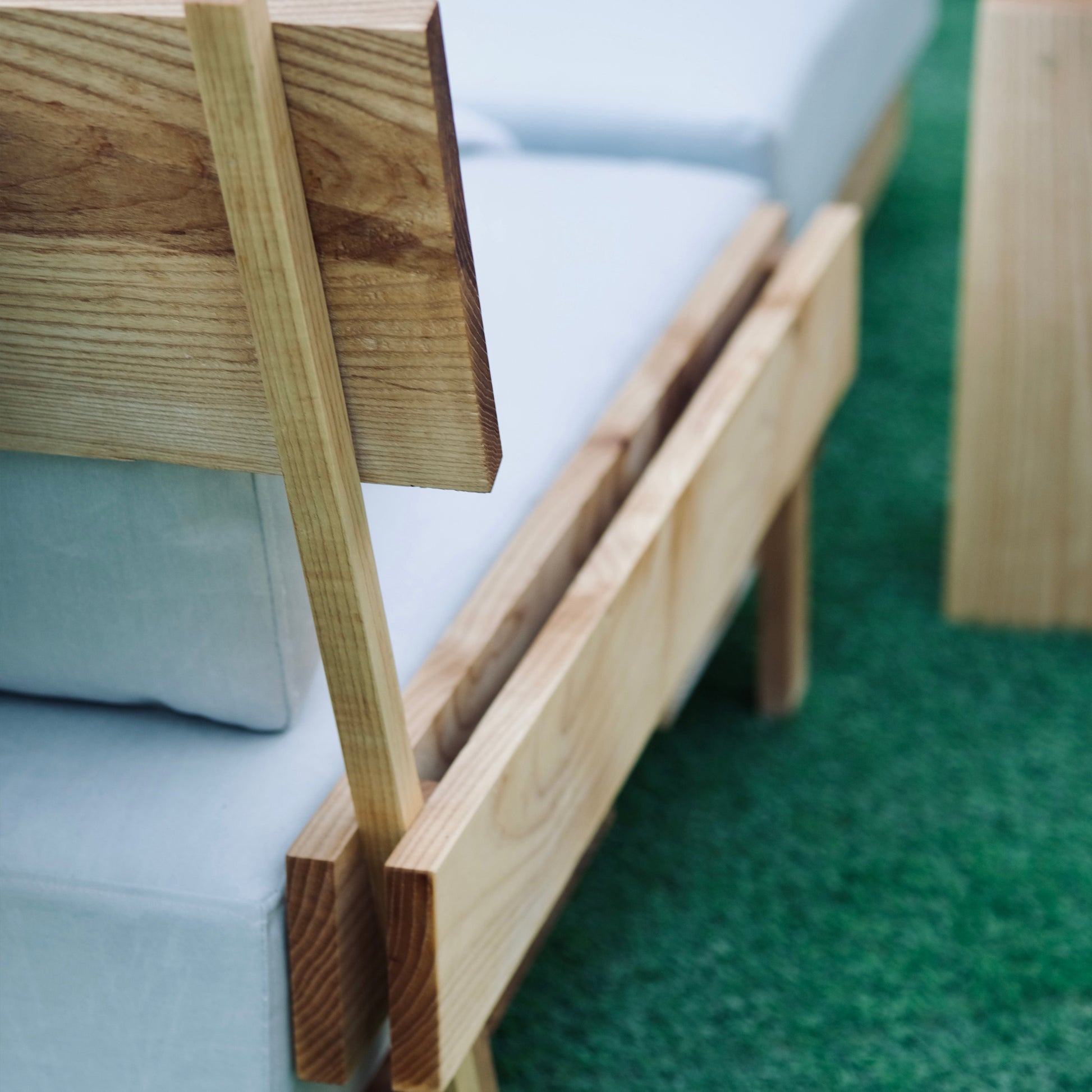Wooden chair with white cushion on a grass floor