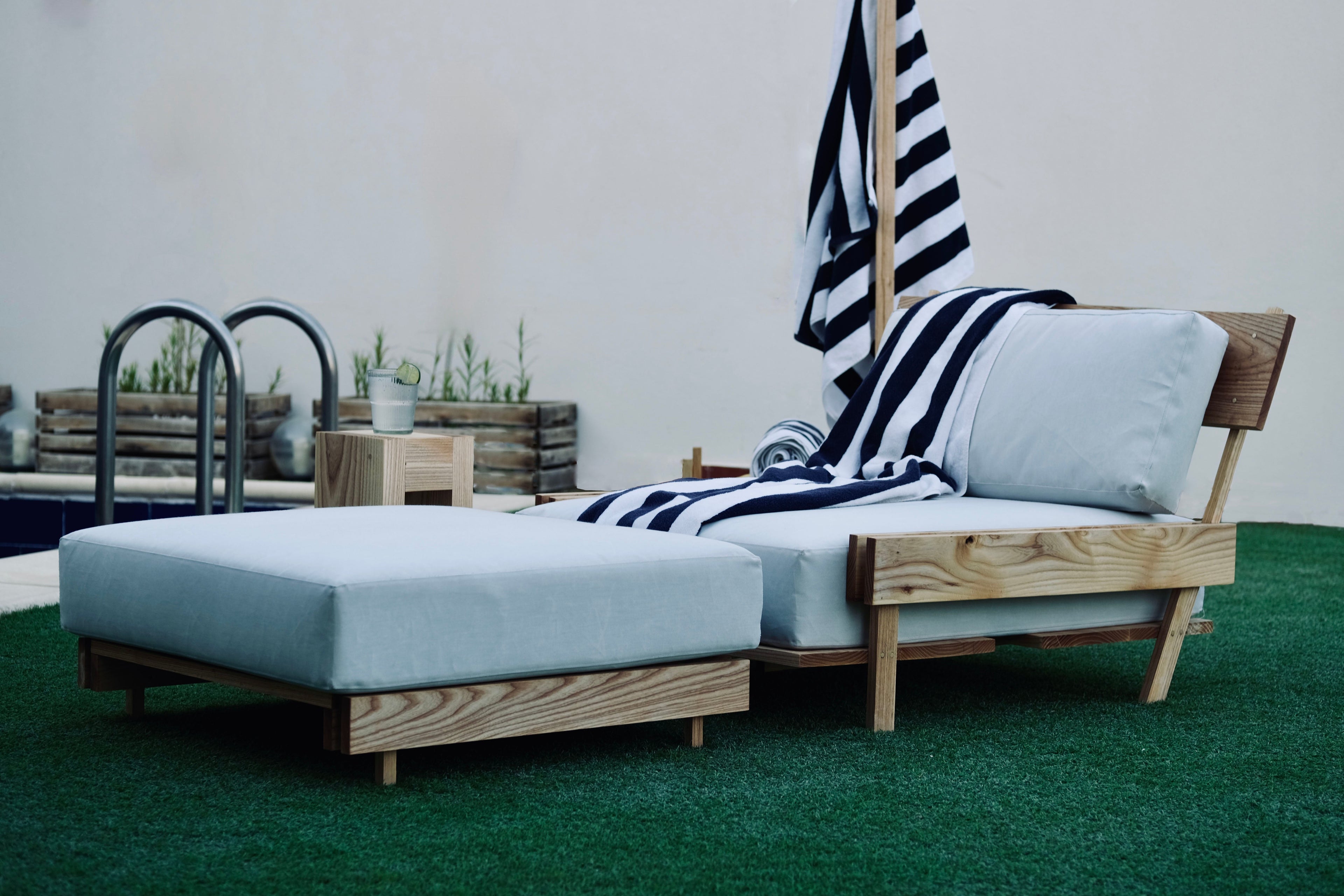 Outdoor furniture set with a striped towel on a white surface