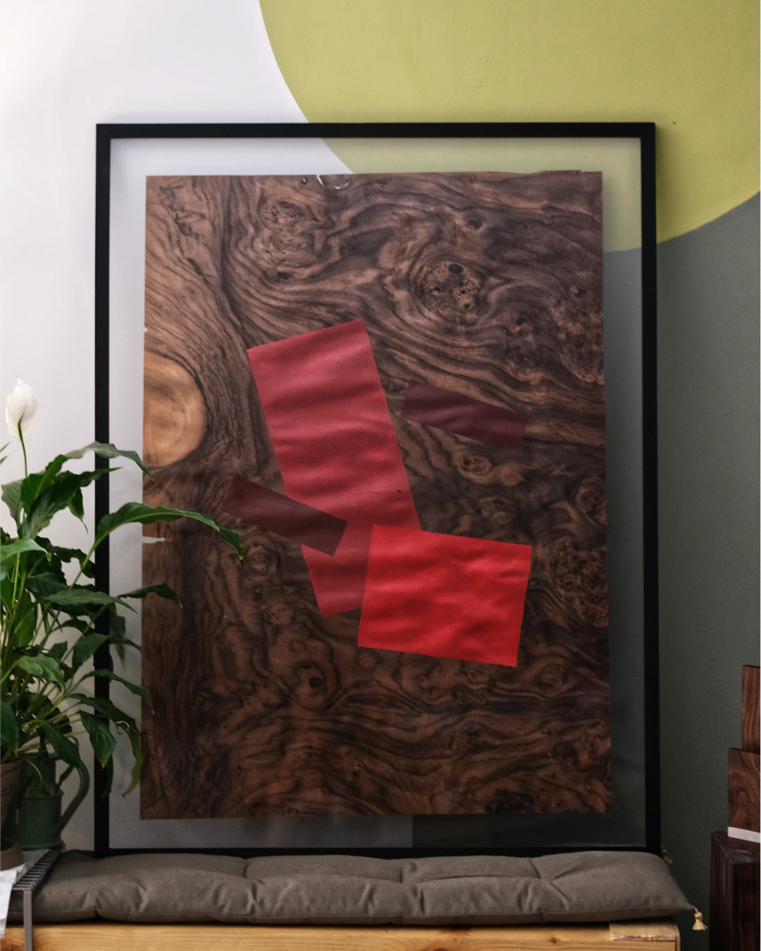 vibrant painting with red chair-inspired shapes on warm walnut veneer.